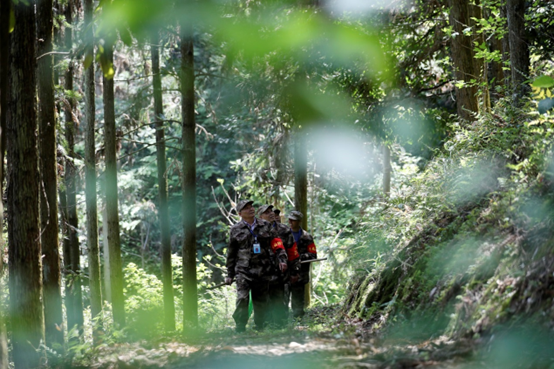 Forest chief Li Yeliang (first on the left) goes on a patrol mission with his colleagues at a state-owned forest farm in Zixing, central China's Hunan province, April 7, 2022. (Photo by Li Ke/People's Daily Online)