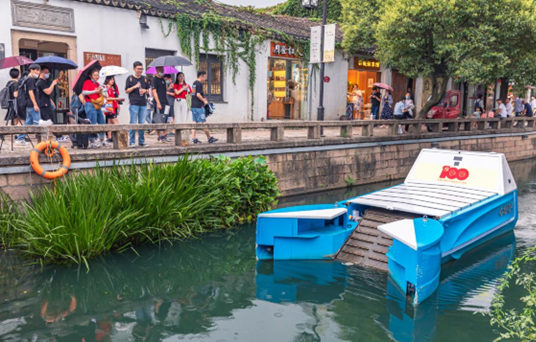 An unmanned cleaning boat attracts the attention of citizens and tourists in Suzhou, east China's Jiangsu Province, July 31, 2021. (Photo by Zhang Feng/People's Daily Online)