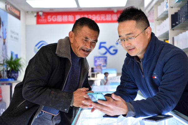 A man buys a 5G mobile phone at a shop in Maqiao township, Baokang county, Xiangyang, central China's Hubei province, Nov. 12, 2021. (Photo by Yang Tao/People's Daily Online)