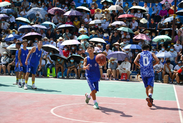 Players of a youth basketball team warm up before a game held in Taipan village, Taipan township, Taijiang county, Qiandongnan Miao and Dong autonomous prefecture, southwest China's Guizhou province, Aug. 9, 2022. (Photo by Cai Xingwen/People's Daily Online)