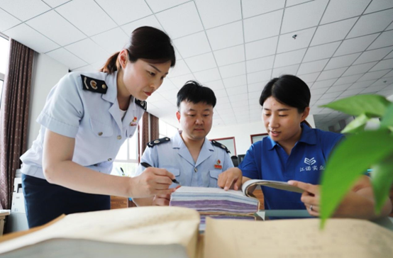 Staff members of a local tax bureau help an employee of a company based in Feixiang district, Handan city, north China's Hebei province with preparation of documents for applying for value-added tax credit refund, June 2022. (Photo by Xue Jiandong/People's Daily Online)