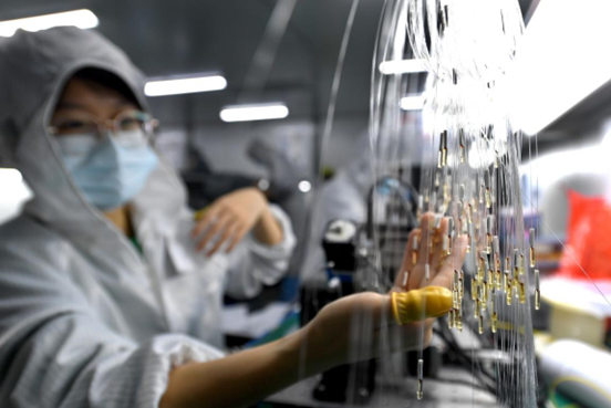 Employees of Wuhan ETERN Optoelectronics Technology Co., Ltd. based in the East Lake High-tech Development Zone, Wuhan, central China's Hubei province, work on a production line, March 25, 2022. (Photo by Zhou Chao/People's Daily Online)