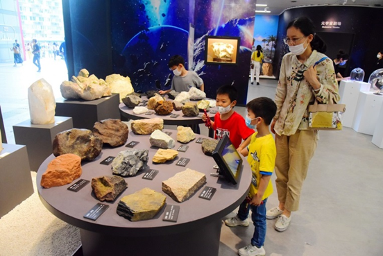 Children watch mineral specimens at Zhejiang Museum of Natural History, June 2022. (Photo by Lian Guoqing/People's Daily Online)