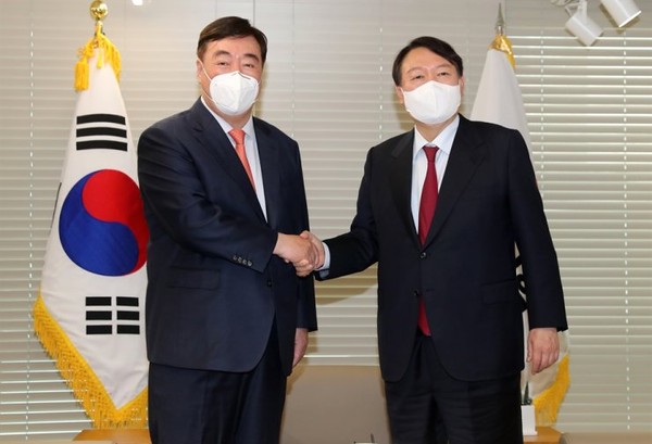 President Yoon Suk-yeol (right) shakes hands with Chinese Ambassador to Korea Xing Haiming.