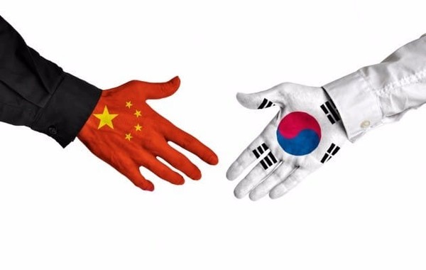 Korea (right) and China come close together for hand-shaking.