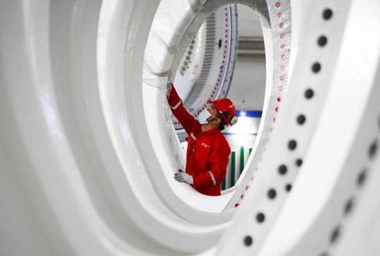 A worker works in a general assembly workshop of a wind-turbine manufacturer in Hami, northwest China's Xinjiang Uygur autonomous region, July 16, 2022. (Photo by Xu Xinghan/People's Daily Online)