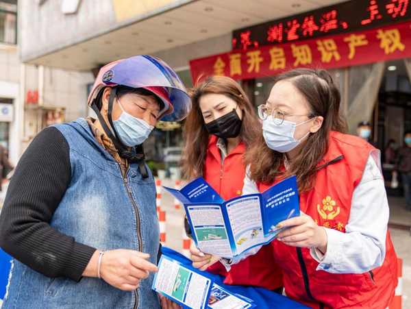 Volunteers explain intellectual property right knowledge to a senior woman in Dagong township, Hai'an, east China's Jiangsu province, April 28, 2022. (Photo by Zhai Huiyong/People's Daily Online)