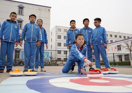 Students of a primary school in Xingtai, north China's Hebei province practice curling on the playground, March, 2021. (Photo by Liu Jidong/People's Daily Online)