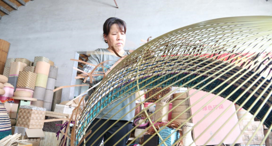 A woman weaves a wicker lampshade in Boxing county, Binzhou, east China's Shandong province, Aug. 26, 2022. (Photo by Shao Qiang/People's Daily Online)