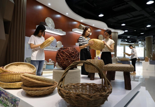 People buy grass weaving products at a grass and wicker weaving-themed industrial park in Boxing county, Binzhou, east China's Shandong province, Aug. 9, 2022. (Photo by Chen Bin/People's Daily Online)
