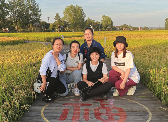 Chen Yujia poses for a picture with her partners in a rice field. (Photo from Women of China magazine) 