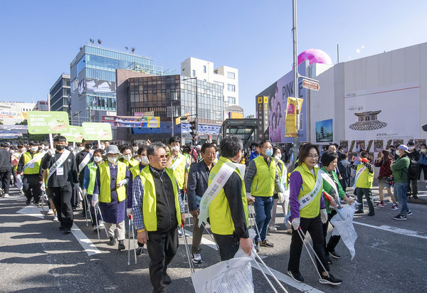 The photo shows Yongsan-gu Mayor Madam Park Hee-young of the Yongsan Ward (right, foreground) carries a pair of garbage-picking gear with other members of her Ward office and the Ward people.