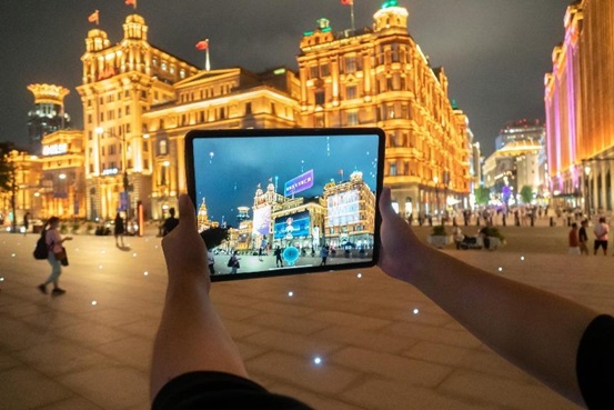 A Shanghai citizen experiences a Metaverse digital twin application on a tablet in the Bund, Shanghai, Aug. 30, 2022. (Photo by Wang Gang/People’s Daily Online)