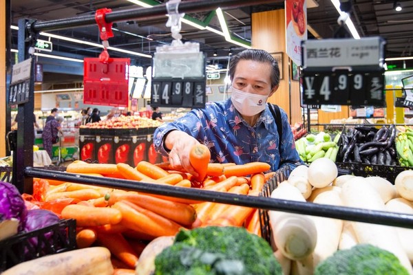 A woman buys vegetables in a supermarket in Nanjing, east China's Jiangsu province, Sept. 9, 2022. (Photo by Su Yang/People's Daily Online)