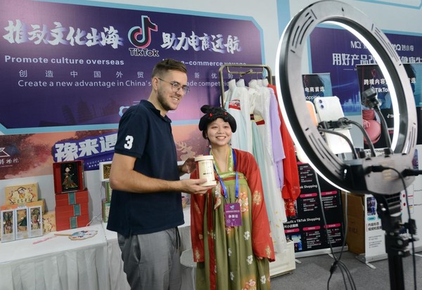 Chinese and foreign hosts sell products to foreign consumers on a livestreaming show in Zhengzhou, central China's Henan province, Aug. 8, 2022. (Photo by Zhang Tao/People's Daily Online)