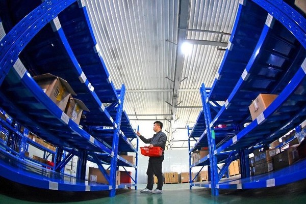 A man fetches products in a cross-border e-commerce warehouse in a comprehensive bonded zone in Lianyungang, east China's Jiangsu province, Oct. 20, 2021. (Photo by Geng Yuhe/People's Daily Online)