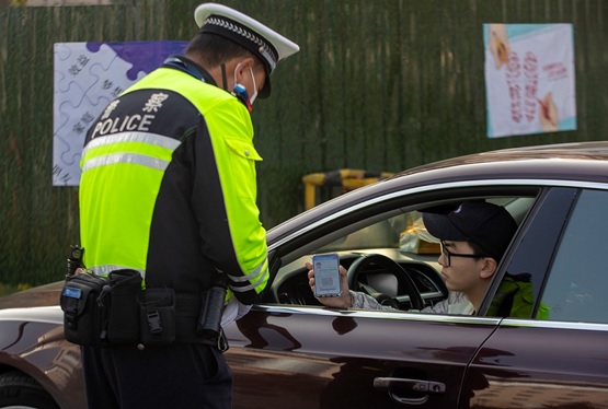 A man shows his digital driver's license to a traffic police officer in Taizhou, east China's Jiangsu province, December, 2021. (Photo by Tang Dehong/People's Daily Online)
