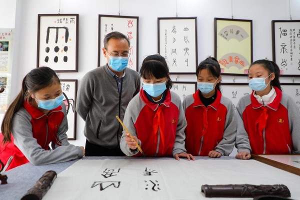 Students learn Chinese calligraphy featuring oracle bone inscriptions in a primary school in Anyang, central China's Henan province, April 18, 2022. (Photo by Ma Xiaoran/People's Daily Online)