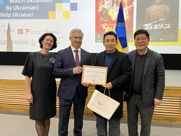 ​The Ukrainian Ambassador to Korea Dmytro Ponomarenko (second from left) and his wife (left), Artist Min (second from right), Vice Chairman Song Na-ra of The Korea Post are taking a commemorative photo of the appreciation plaque delivery.