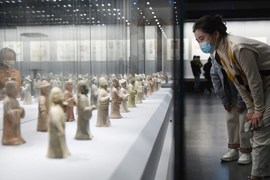 A woman watches cultural relics displayed at an exhibition of Ming Dynasty (1368-1644) treasures held at Fuyang, east China's Anhui province, November, 2022. (Photo by Wang Biao/People's Daily Online)