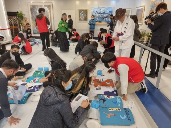 International students from the World Cup participating countries are attending a flag-drawing event on a thousand-year tile.