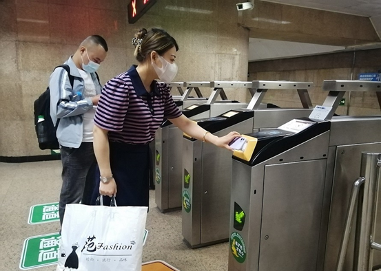 Passengers have their QR codes scanned to get into a subway station in Beijing, June 2022. (Photo by Du Jianpo/People's Daily Online)