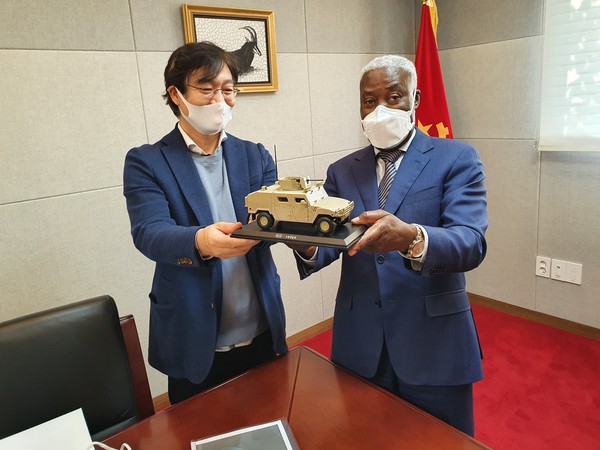 An executive of KIA Export department offering a prototype of one of their vehicles to Angola Ambassador