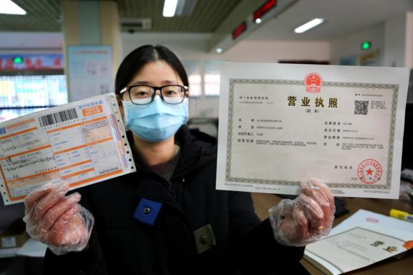 An official with the market regulation bureau of Lianyun district, Lianyungang, east China's Jiangsu province ships a business license to an enterprise that applied for the document online, Feb. 17, 2020. (Photo by Wang Chun/People's Daily Online)