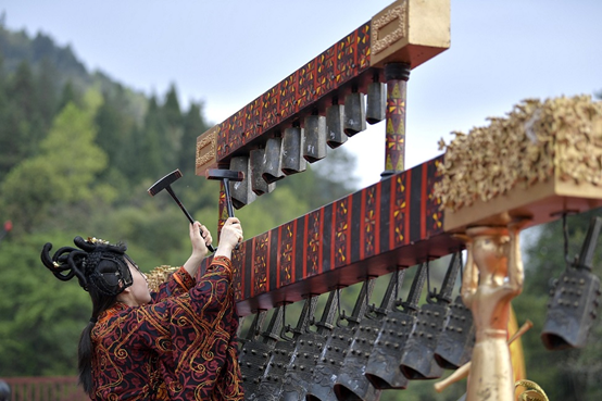 Photo taken in March 2021 shows a woman playing chime bells at the cultural square of Wujiatai village, Wanzhai township, Xuan'en county, central China's Hubei province. (Photo by Song Wen/People's Daily Online)
