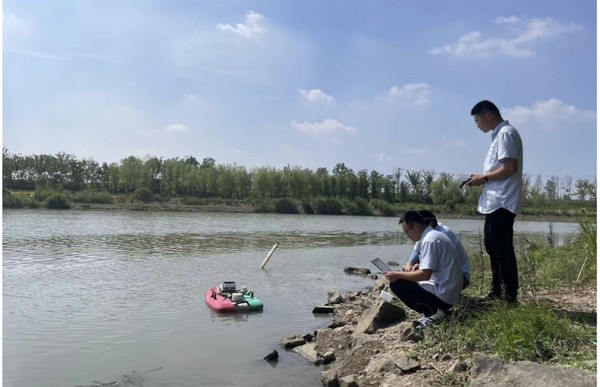 Engineers of the environmental monitoring center of Nanjing, east China's Jiangsu province use an unmanned boat for water monitoring of a local river. (Photo from Jiangsu News Radio)