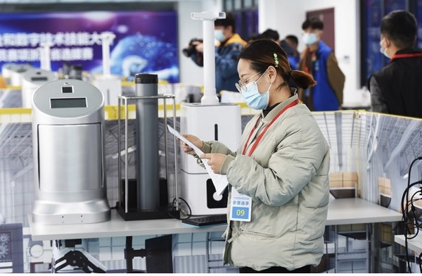 A woman competes in the Zhejiang division of a national new profession and digital skills competition as a service robot application technician, November 2021. (Photo by Gong Xianming/People's Daily Online)