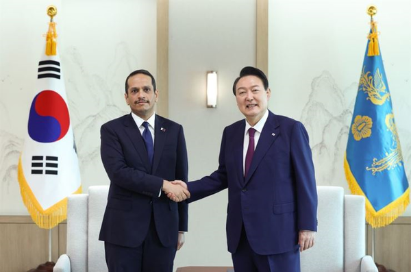 President Yoon Suk-yeol, right, poses with Qatar's deputy prime minister and foreign minister, Mohammed bin Abdulrahman Al Thani.