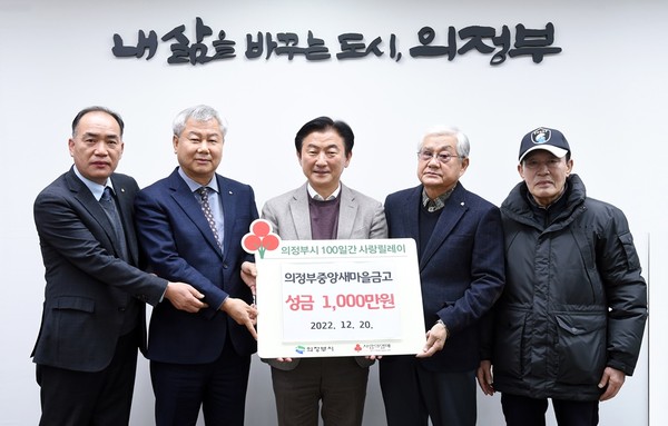 Mayor Kim (center) is holding a sign with donor represeentatives showing the sign of a 10 million Won donation from the Cetral Saemeul Bank of the Uijeongbu City for the development of the city.