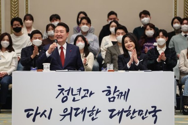 President Yoon Suk-yeol (left) speaks at a meeting of reform in the three major areas of labor, education, and pension with about 200 young people at the Blue House guesthouse on Dec. 20. First Lady Kim Keon-hee is clapping on the right.