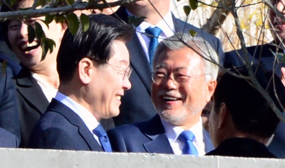 Former President Moon Jae-in (right) smiles while taking a commemorative photo with Lee Jae-myung, chairman of the Democratic Party of Korea, at his private residence in Pyeongsan Village, Yangsan-si, Gyeongsangnam-do on Jan. 2, 2023.