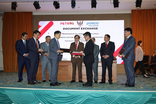 Cho Ju-ik, head of POSCO Hydrogen business division (fourth from the left), and Anyi Ngau, head of PETROS’ Sarawak Resource Management Division (sixth from the left), are exchanging MOU documents.
