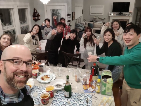 In this photo posted on the Facebook account of Alexander Campagna, he, his wife and 10 stranded travelers from South Korea pose for a photo after a dinner party on Dec. 24, 2022.