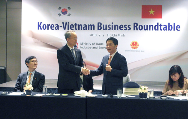 Trade, Industry and Energy Minister Paik Ungyu (second from left) shakes hands with Vietnam’s Industry and Trade Minister Tran Tuan Anh (second from right) at the Korea-Vietnam Business Roundtable at a hotel in Ho Chi Minh City on Feb. 2, 2018.