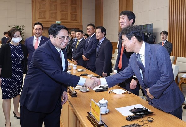 Prime Minister Pham Minh Chinh (left) greets representatives of Korean associations and businesses at the meeting in Hanoi on July 30.