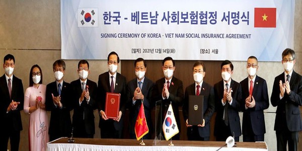 Vietnamese Labor Minister Dao Ngoc Dung (5th from left) and South Korean Health Minister Kwon Deok-cheol (4th from right) pose for a photo after signing the bilateral social insurance agreement in Seoul on Dec. 14, 2021. 