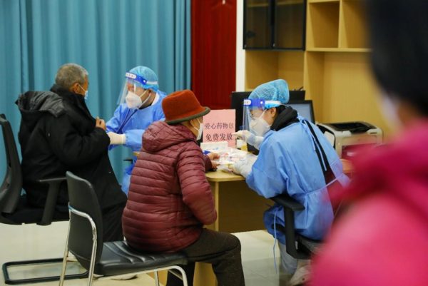 Doctors offer free services to residents and give free medicine to them in a community health center in Qingdao, east China's Shandong province, Dec. 21, 2022. (Photo by Zhang Ying/People's Daily Online)