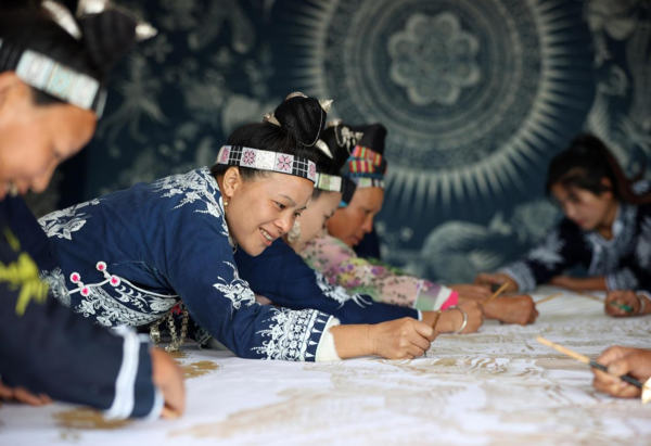 Women of Miao ethnic group make batik products in a poverty-alleviation batik workshop in Danzhai county, southwest China's Guizhou province, Oct. 7, 2022. Batik is a local intangible cultural heritage in the province. (Photo by Huang Xiaohai/People's Daily Online)