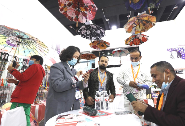 Foreigners buy umbrellas at the Yiwu International Expo Center, Yiwu, east China's Zhejiang province, Nov. 24, 2022. (Photo by Gong Xianming/People's Daily Online)