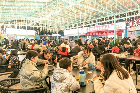Citizens enjoy food in a night market in Huaying, southwest China's Sichuan province, Dec. 31, 2022. (Photo by Qiu Haiying/People's Daily Online)