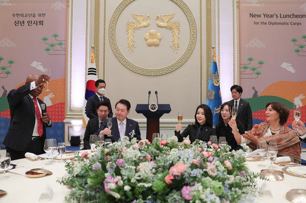 President Yoon Suk-yeol and First Lady Kim Kun-hee (center, seated) are responding to a toast proposed by Gabon Amb. to Korea Carlos Viktor Boungou (left), the head of the foreign diplomatic corps in Korea, at a New Year's greeting ceremony held at the Blue House guesthouse on Jan. 31.