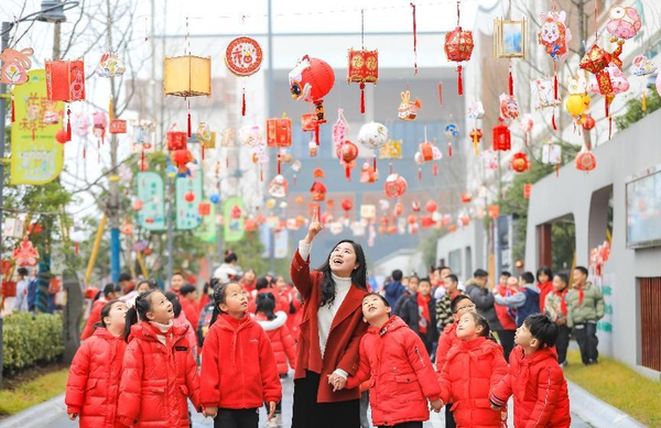 A teacher and her students watch homemade lanterns at an elementary school in Changxing county, Huzhou, east China's Zhejiang province, Feb. 6, 2023. (Photo by Zhou Hongfeng/People's Daily Online)
