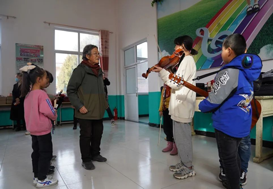 Deng Xiaolan teaches music to children from Malan village, Fuping county, Baoding city, north China's Hebei Province. (Photo courtesy of the publicity department of the Party committee in Fuping)