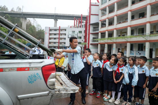 An official with the meteorological bureau of Huaying, southwest China's Sichuan province tells students the functions of a cloud seeding rocket. (Photo by Qiu Haiying/People's Daily Online)