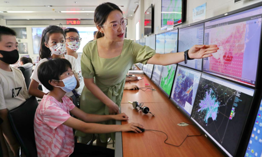 An official with the meteorological bureau of Qinhuangdao, north China's Hebei province shares meteorological knowledge with local students. (Photo by Cao Jianxiong/People's Daily)