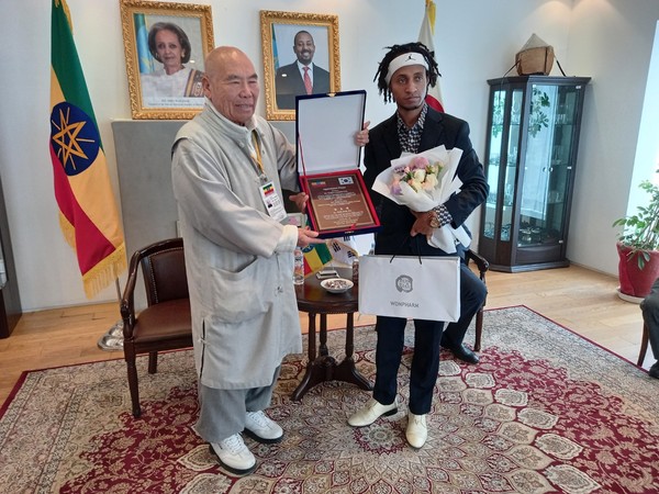 Ven. Chief Monk Hyangdeok (left) poses with Wakjera Gemechu Guta after presenting a plaque of merit and a gift of money to the Ethiopian young man who showed heroic and exemplar activities to save a Korean lady in a terrible accident in Itaewon, Seoul last October.